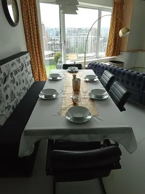 a dining room table with plates and glasses on it at Liège centre Médiacité appartement possible parking terrasse immense 8ème pour 2 personnes in Liège