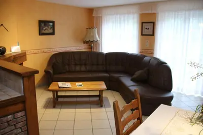 a living room with a leather couch and a table at Gîtes de Chevémont in Plombières