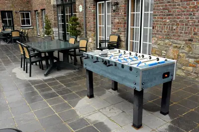 a ping pong table in the middle of a patio at Gîtes de Chevémont in Plombières