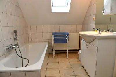 a bathroom with a bath tub and a sink at Gîtes de Chevémont in Plombières