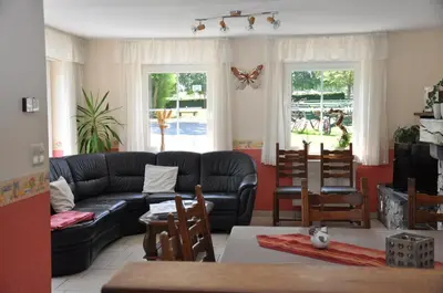 a living room with a couch and tables and chairs at Gîtes de Chevémont in Plombières
