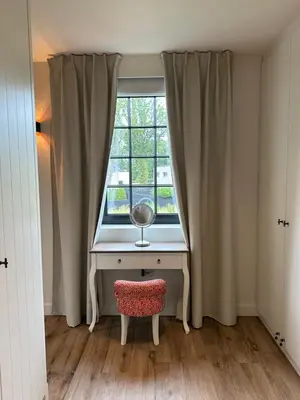 a desk in front of a window with a mirror at Het Herenhuis in Genk