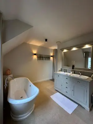 a bathroom with a large tub and a large mirror at Het Herenhuis in Genk