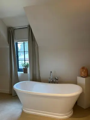 a white bath tub in a bathroom with a window at Het Herenhuis in Genk