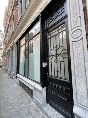 a black door on a building on a street at St Catherine in Liège