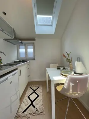 a kitchen with a white table and a white chair at St Catherine in Liège