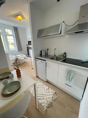 a white kitchen with a sink and a table at St Catherine in Liège