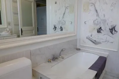 a white bathroom with a tub and a mirror at B&B Matin Tranquille in Liège