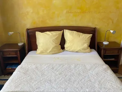 a bedroom with a bed with two nightstands and two lamps at B&B Matin Tranquille in Liège