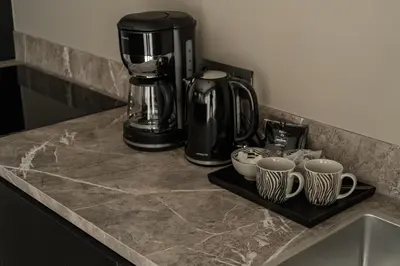 a counter with a coffee maker and cups on it at Luxury house 