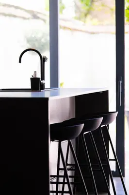 a kitchen with a sink and two bar stools at Garden Guillemins Station in Liège
