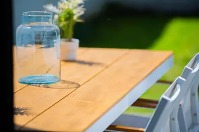 a wooden table with a vase of flowers on it at Garden Guillemins Station in Liège