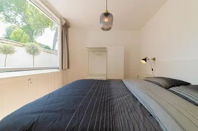 a bedroom with a bed and a large window at Garden Guillemins Station in Liège