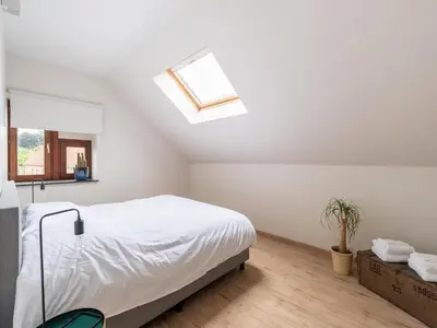 a white bedroom with a bed and a skylight at Scenic villa in Borgloon with garden in Borgloon