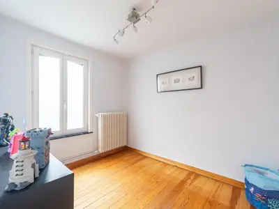 an empty living room with white walls and wooden floors at Scenic villa in Borgloon with garden in Borgloon