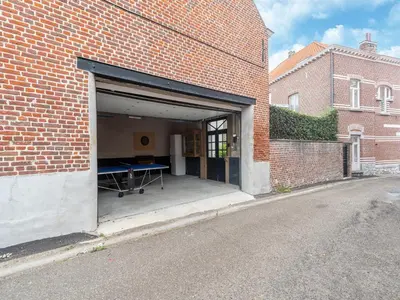 a garage with a ping pong table inside of a brick building at Scenic villa in Borgloon with garden in Borgloon