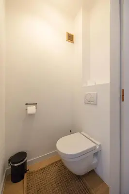 a bathroom with a white toilet and a trash can at Het Generaaltje in Hasselt