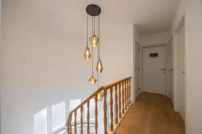 a hallway with a staircase with a chandelier at Het Generaaltje in Hasselt