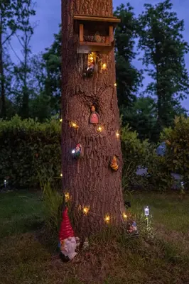 a tree with a bird house and lights on it at 't Bunga huiske in Lanaken