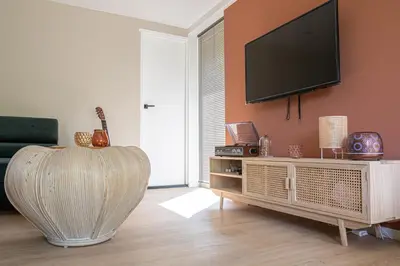 a living room with a flat screen tv on a wall at 't Bunga huiske in Lanaken