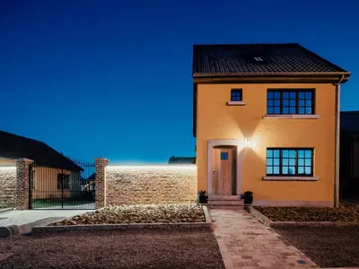 a yellow brick house with a door in front at Welldone Resort / Cozy Wine in Nieuwerkerken
