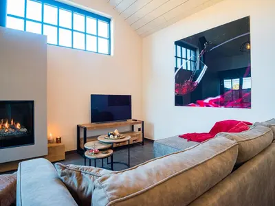 a living room with a couch and a fireplace at Welldone Resort / Cozy Wine in Nieuwerkerken