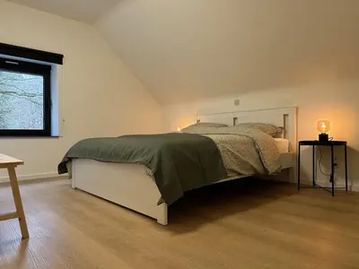 a bedroom with a bed and a window at De Bovenbuur in Lummen