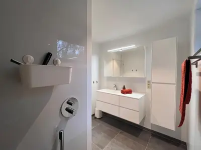a white bathroom with a sink and a mirror at De Bovenbuur in Lummen