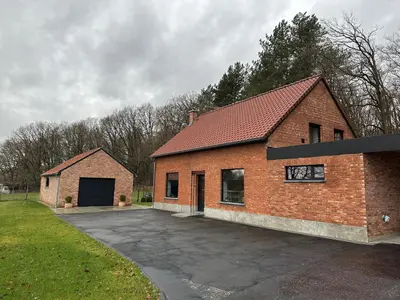 a brick house with a garage and a driveway at De Bovenbuur in Lummen
