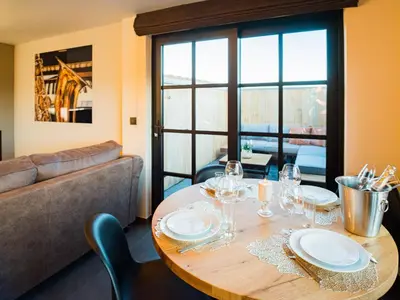 a dining room with a table and a couch at Welldone Resort - Cozy Saxofoon in Nieuwerkerken