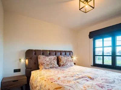 a bedroom with a large bed and a window at Welldone Resort - Cozy Saxofoon in Nieuwerkerken