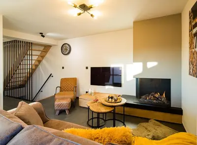 a living room with a couch and a fireplace at Welldone Resort - Cozy Saxofoon in Nieuwerkerken