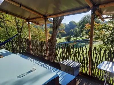 a gazebo with a table and a view of a river at Le Bunker du Houyeux in Herve