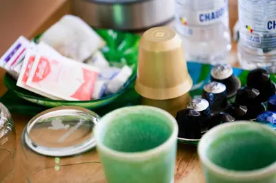 a wooden table topped with green cups and other items at Côté cour, côté source chambre d'hôtes in Chaudfontaine
