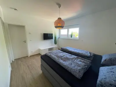 a bedroom with two beds and a pendant light at Casa 47 in Eupen