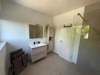 a bathroom with a sink and a glass shower at Casa 47 in Eupen