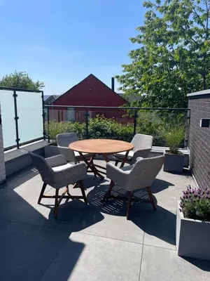 a wooden table and chairs on a patio at Casa 47 in Eupen
