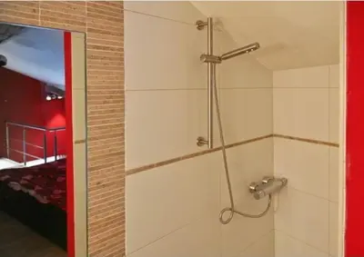 a shower stall in a room with a bedroom at Jacuzzi - BBq - Jardin - Garden Lodge - Le Tulipier in Olne