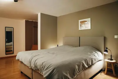 a bedroom with a large bed in a room at L'Orée du Bois by WelcHome in Verviers