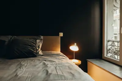 a bedroom with a bed and a lamp next to a window at Liège City by WelcHome in Liège