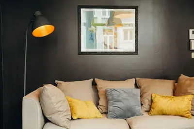 a living room with a white couch with pillows at Liège City by WelcHome in Liège