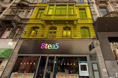 a yellow building with a store in front of it at Liège City by WelcHome in Liège