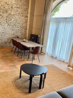 a dining room with a table and chairs and a stool at Le Val du Cossart by WelcHome in Verviers
