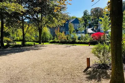 a park with trees and a house in the background at Jacuzzi - Sauna - BBq - Jardin - Garden Lodge - Myosotis in Olne