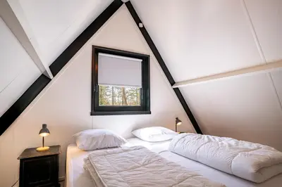 a bedroom with two beds and a window at Boshuisje Rekem - Topo in Lanaken