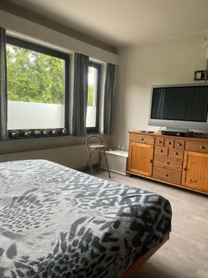 a bedroom with a bed and a flat screen tv at Homestay La Montagne des Coeurs in Eigenbilzen