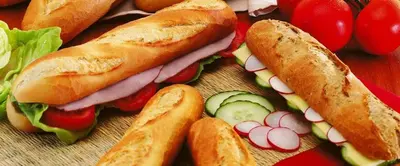 a sandwich and vegetables on a cutting board at Homestay La Montagne des Coeurs in Eigenbilzen