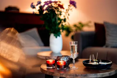 a table with a wine glass and a vase with flowers at Bij de secretaris in Kanne