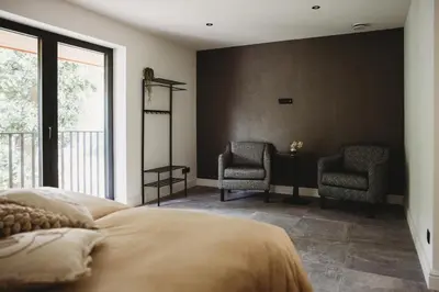 a bedroom with a bed and two chairs at Eikenhoef in Lommel