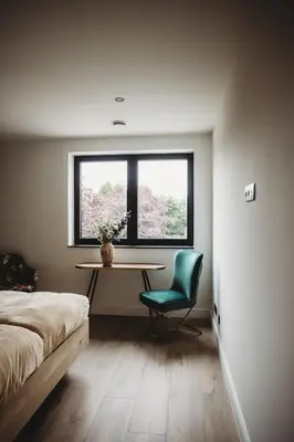 a bedroom with a table and a chair and a window at Eikenhoef in Lommel